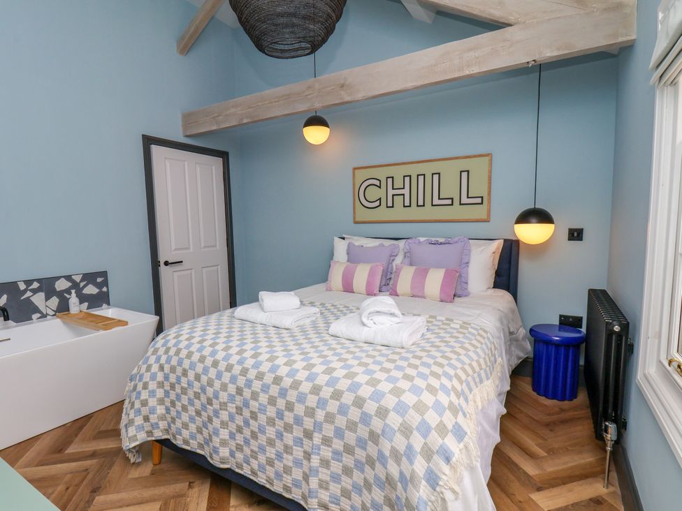 A bedroom with a bed and wash basin at Apartment Blue in Whitby