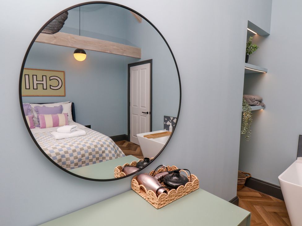 A bedroom with a bed and mirror at Apartment Blue in Whitby