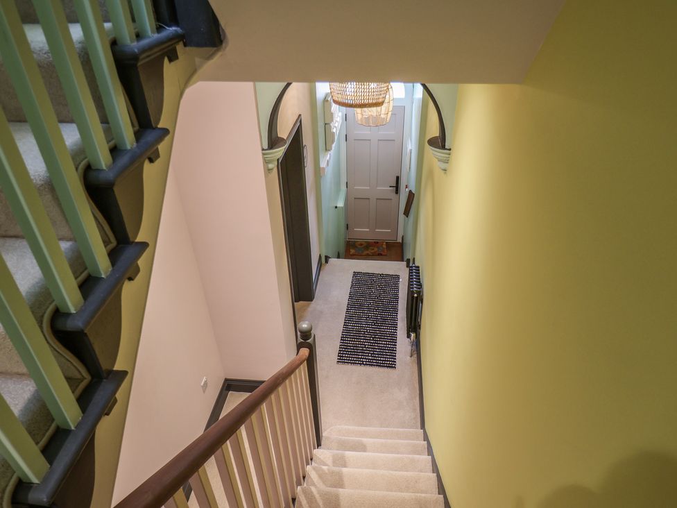 A hallway with stairs leading to a door at Apartment Green in Whitby