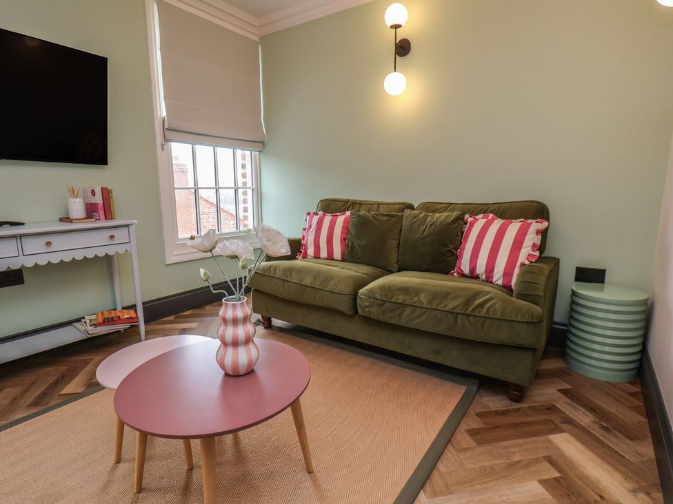 A living room with a green sofa and a coffee table at Apartment Green in Whitby