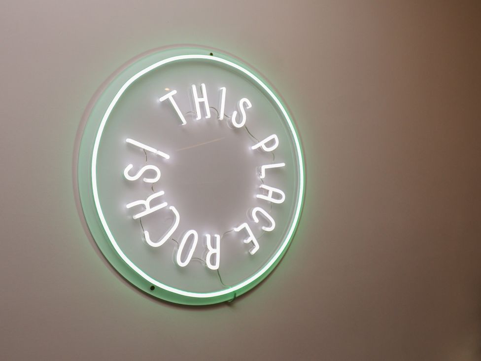 A neon sign saying 'THIS PLACE ROCKS'