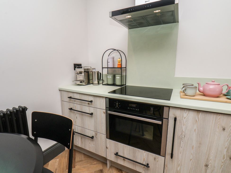 A kitchen with a stove, oven, and coffee machine at Apartment Green in Whitby