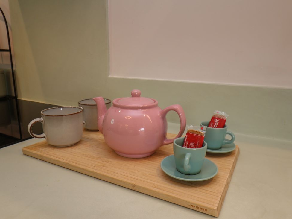 A tea set with a pink teapot and cups on a tray at Apartment Green in Whitby