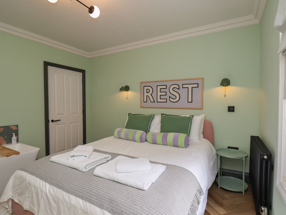 A bedroom with a bed and green accents at Apartment Green in Whitby