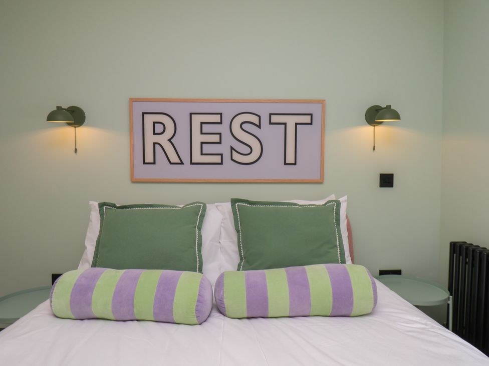 A bedroom with pillows and wall art at Apartment Green in Whitby