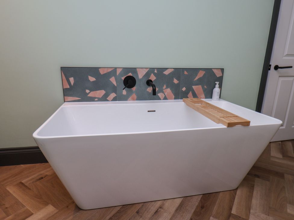 A bathtub with a wooden tray at Apartment Green in Whitby