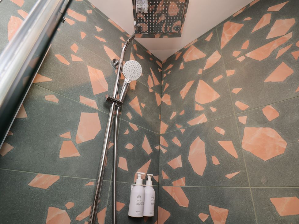 A shower with tiles and products in a bathroom at Apartment Green in Whitby
