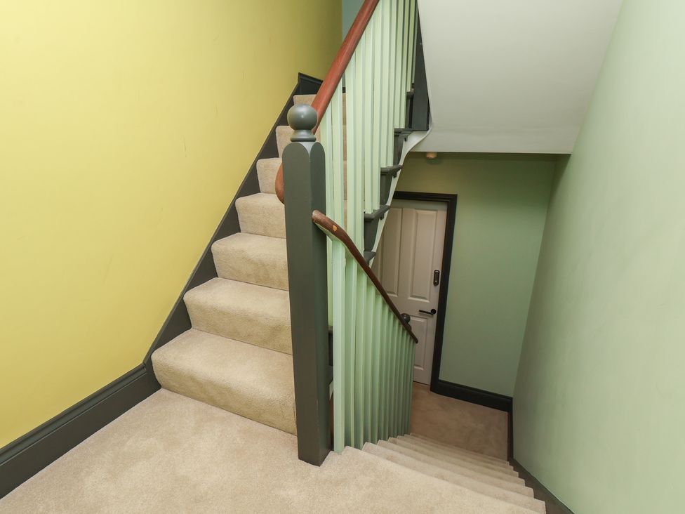 A staircase with a handrail and door at Apartment Green in Whitby