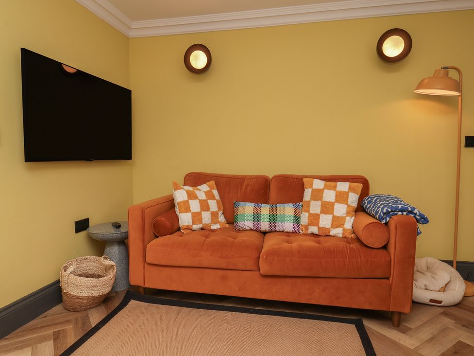 A living room with a sofa and television at Apartment Yellow in Whitby