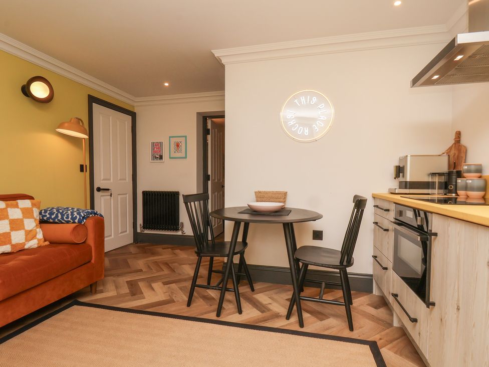A living room with a sofa and dining area at Apartment Yellow in Whitby