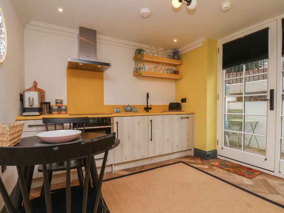 A kitchen with appliances and furniture at Apartment Yellow in Whitby