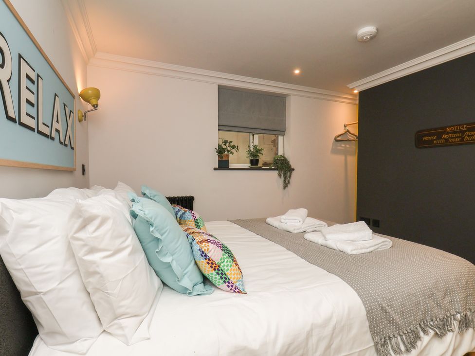 A bedroom with a bed and decorative cushions at Apartment Yellow in Whitby