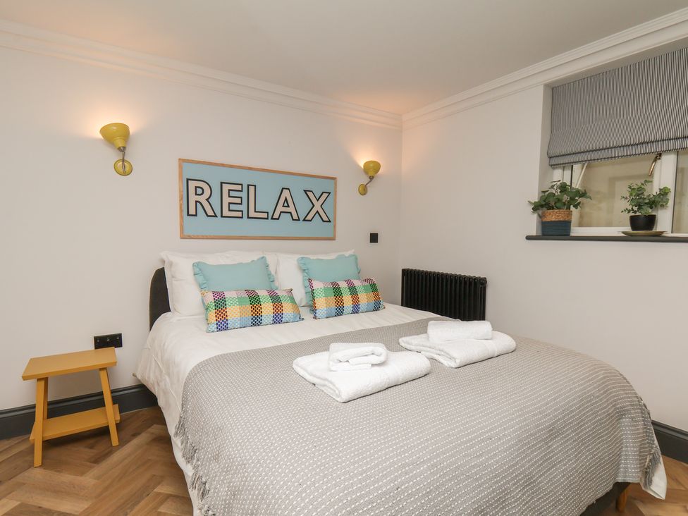 A bedroom with a bed and wall art at Apartment Yellow in Whitby