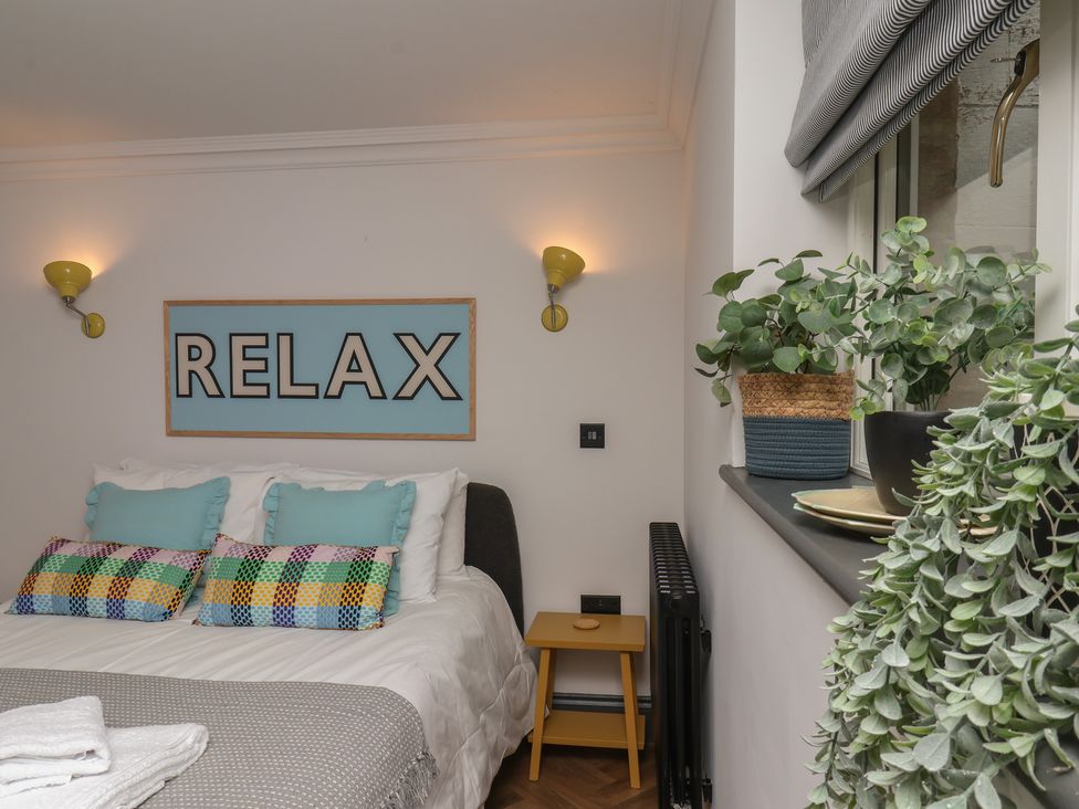 A bedroom with a bed and decorative items at Apartment Yellow in Whitby