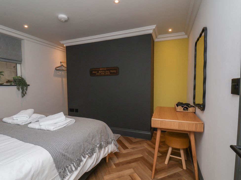 A bedroom with a bed and a desk at Apartment Yellow in Whitby