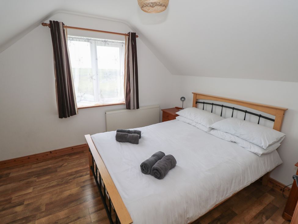 A bedroom with a bed and bedside table at Islands Inn in Louisburgh, County Mayo
