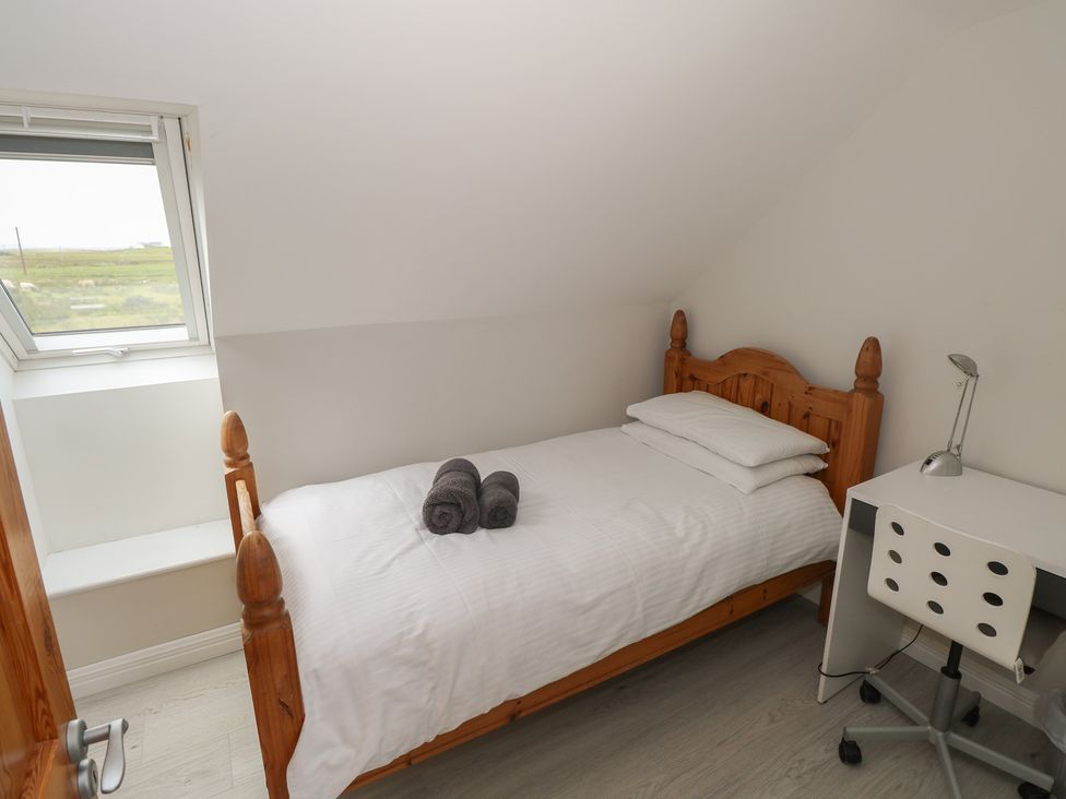 A bedroom with a bed and desk at Islands Inn in Louisburgh, County Mayo