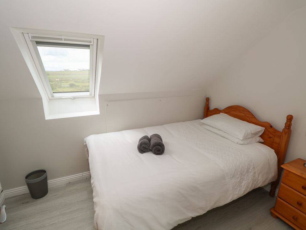 A bedroom with a bed and towels at Islands Inn in Louisburgh, County Mayo