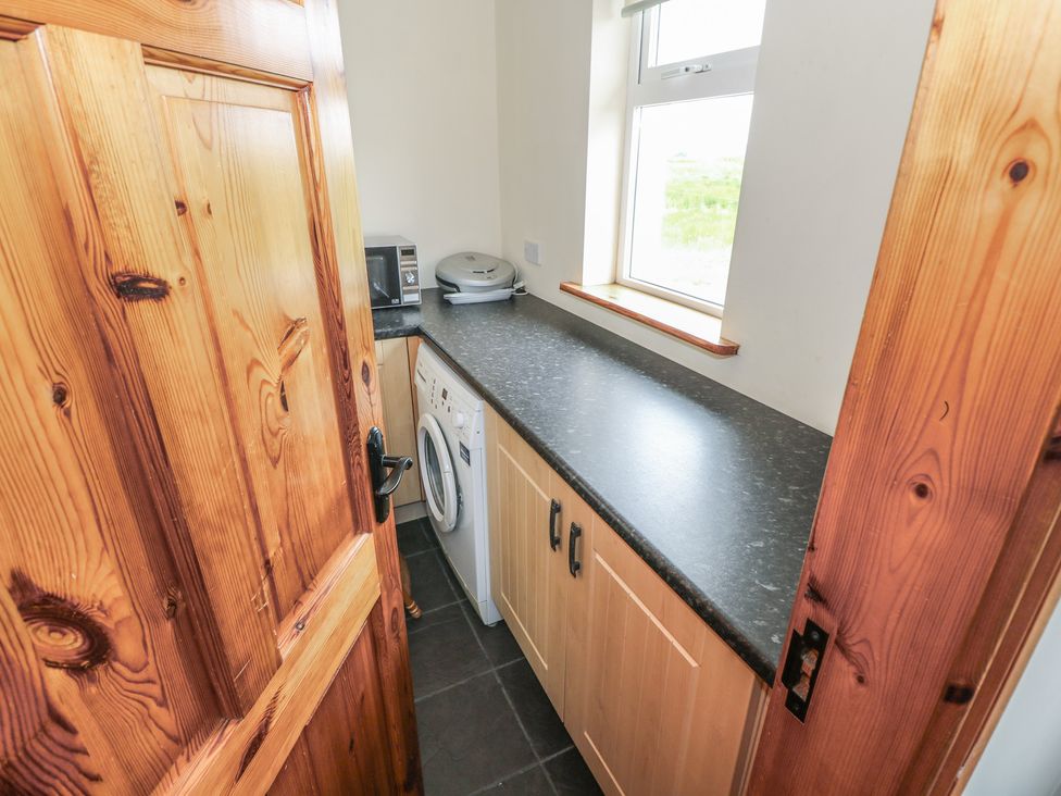 A utility room with a washing machine and countertop at Islands Inn in Louisburgh, County Mayo