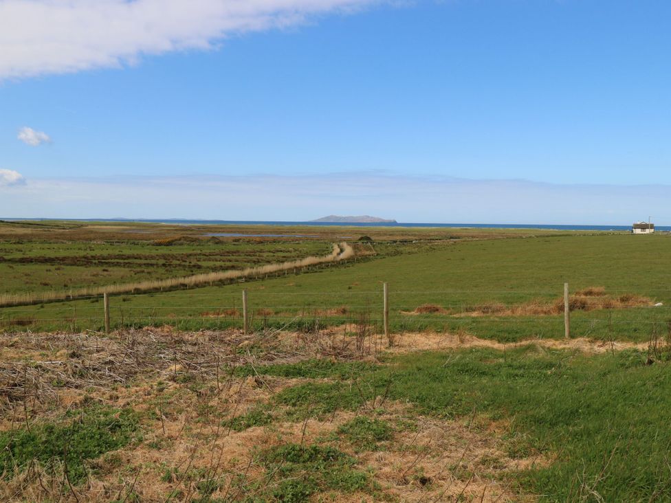 A scenic view of a field with water and an island at Islands Inn, Louisburgh, County Mayo
