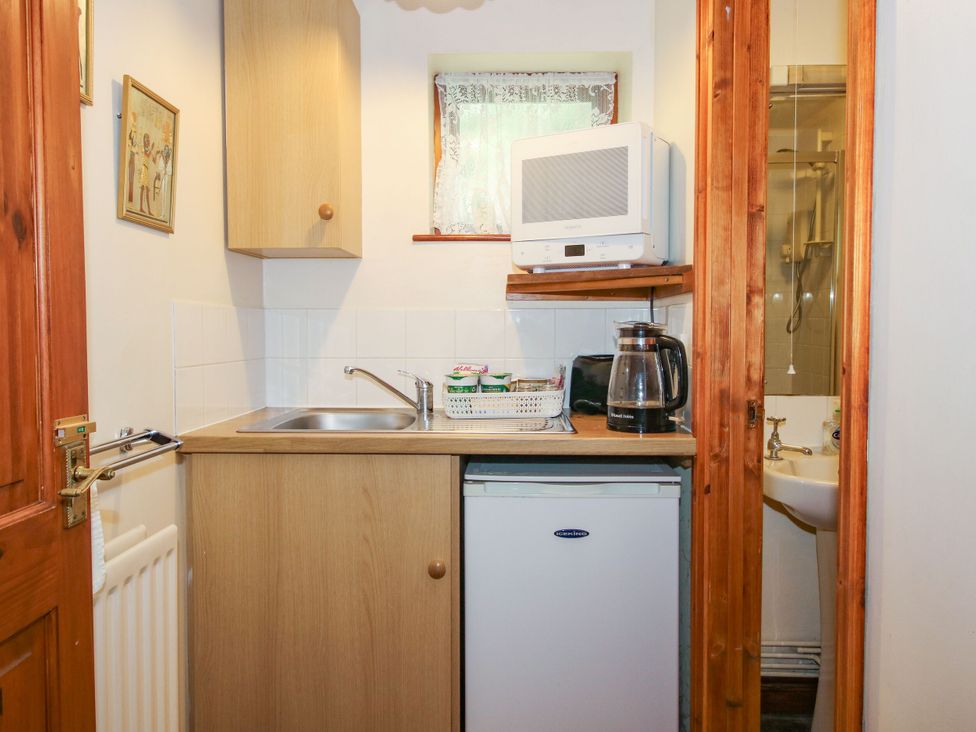 A kitchenette with a sink and appliances at Apartment 1 in Lydbury North