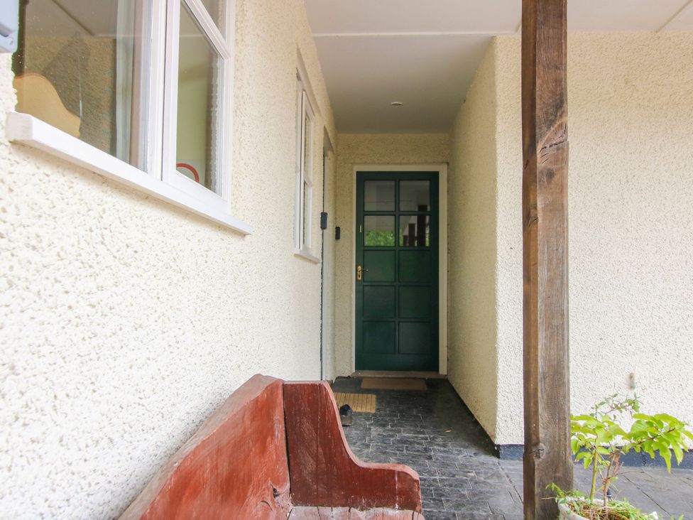 An entryway featuring a green door and a wooden bench at Apartment 1 in Lydbury North