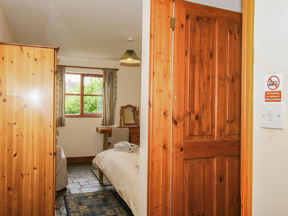 A bedroom with wardrobe and window at Apartment 1 in Lydbury North