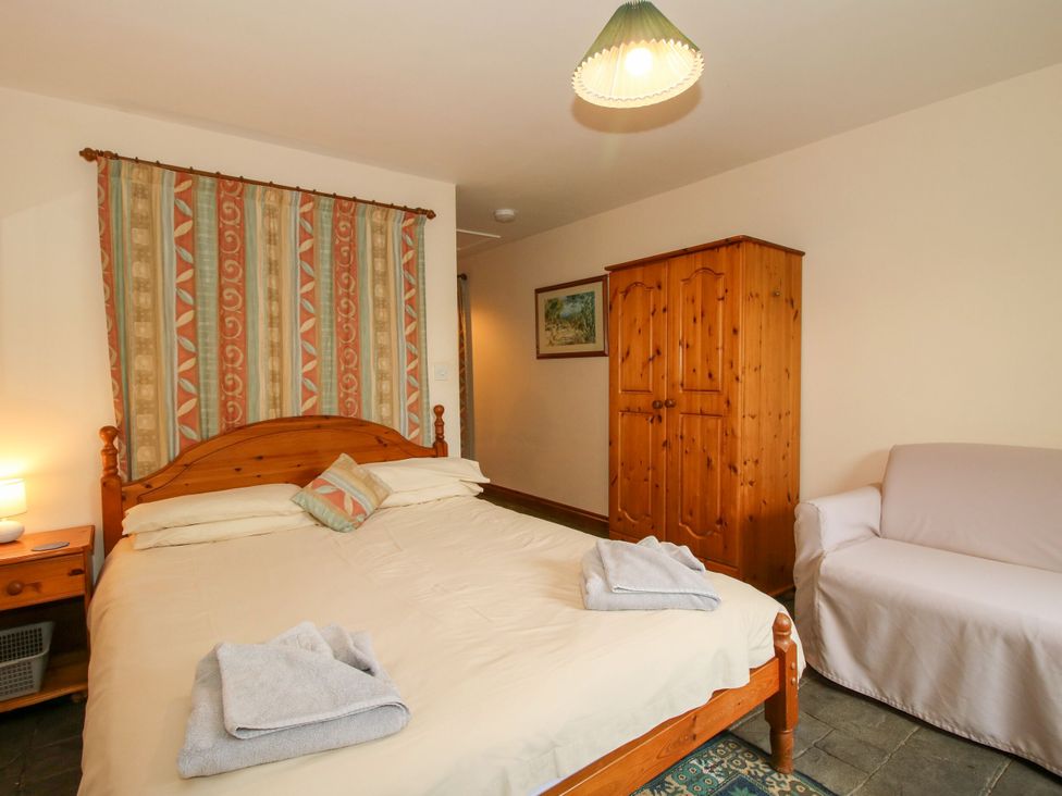 A bedroom with a bed, wardrobe, and lamp at Apartment 1 in Lydbury North