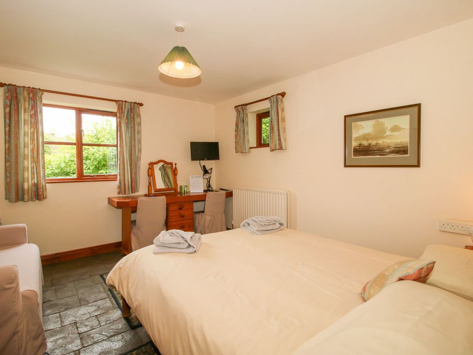 A bedroom with a bed, desk, and window at Apartment 1 in Lydbury North