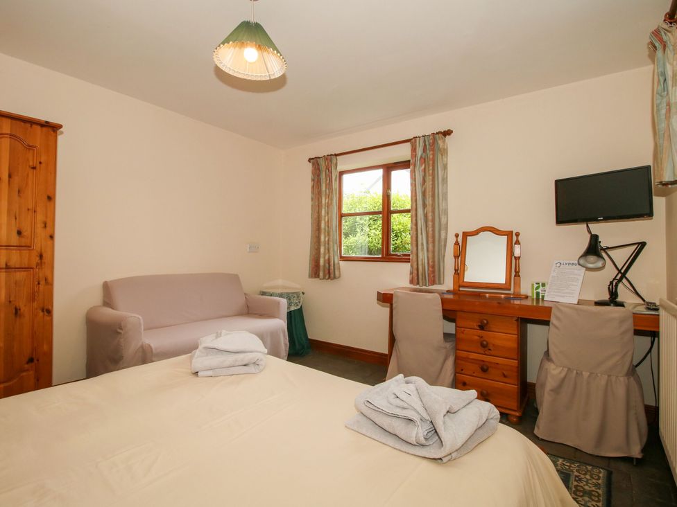 A bedroom with a bed, sofa, desk, and wardrobe at Apartment 1 Lydbury North