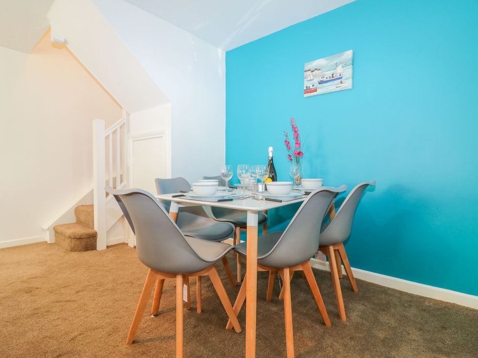 A dining room with a table and chairs at Broadsands Cottage in Paignton