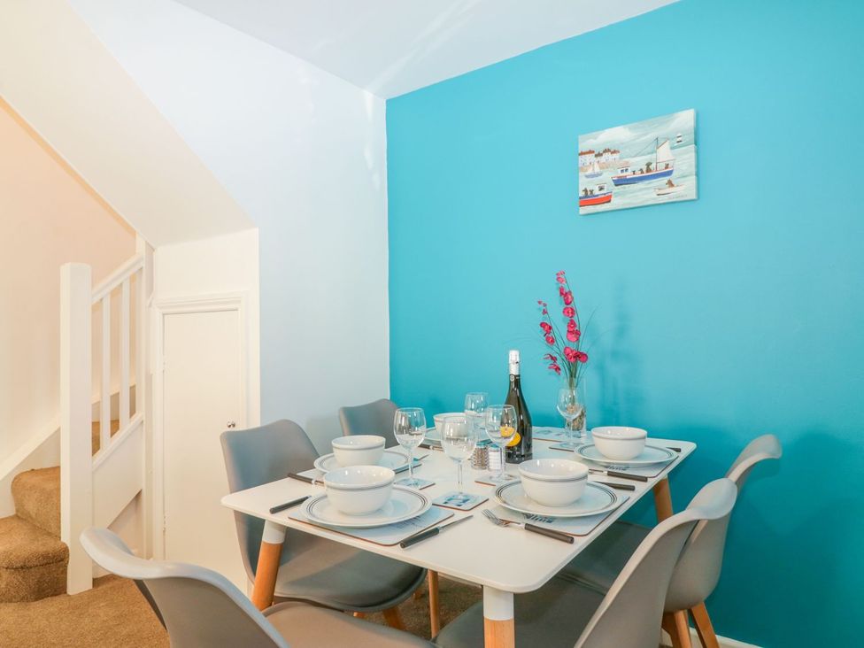 A dining room with a table set for a meal at Broadsands Cottage in Paignton