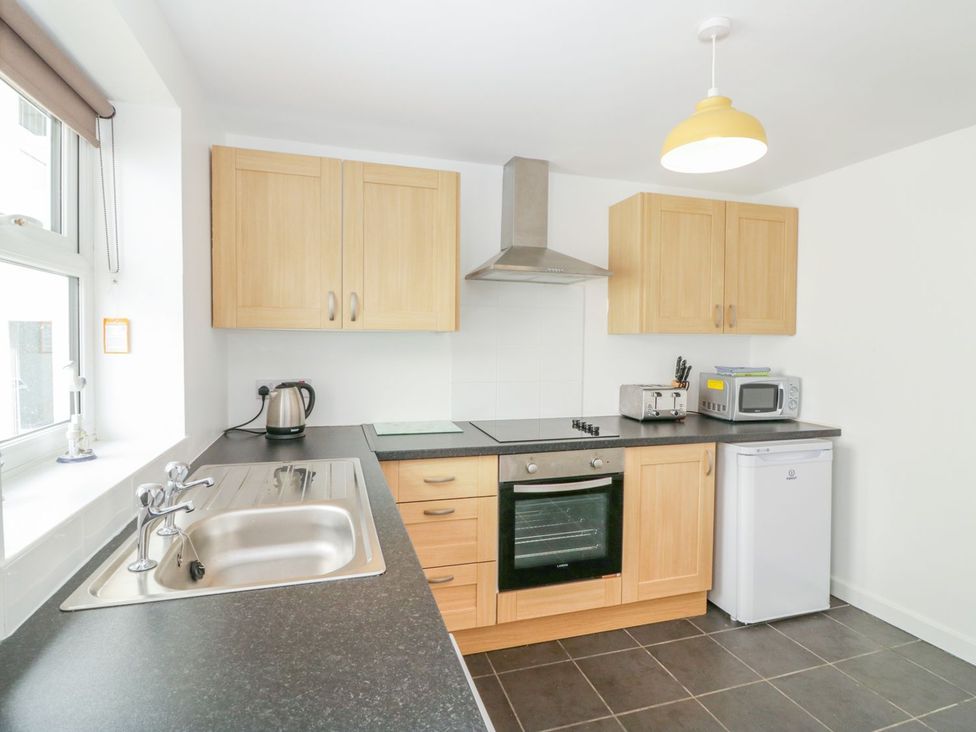 A kitchen with sink, oven, and appliances at Broadsands Cottage in Paignton