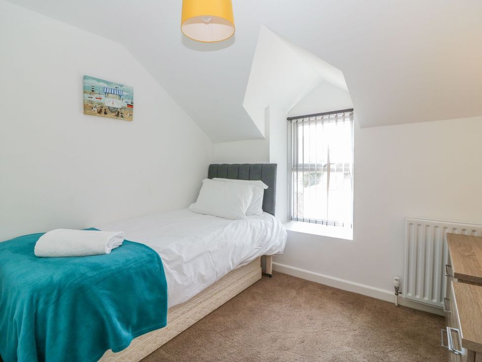 A bedroom with a single bed and desk at Broadsands Cottage in Paignton