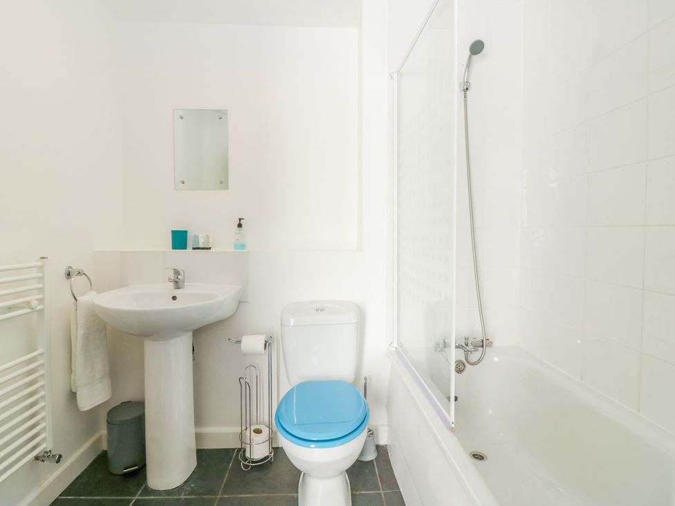 A bathroom with sink, toilet, bathtub, and shower at Broadsands Cottage in Paignton