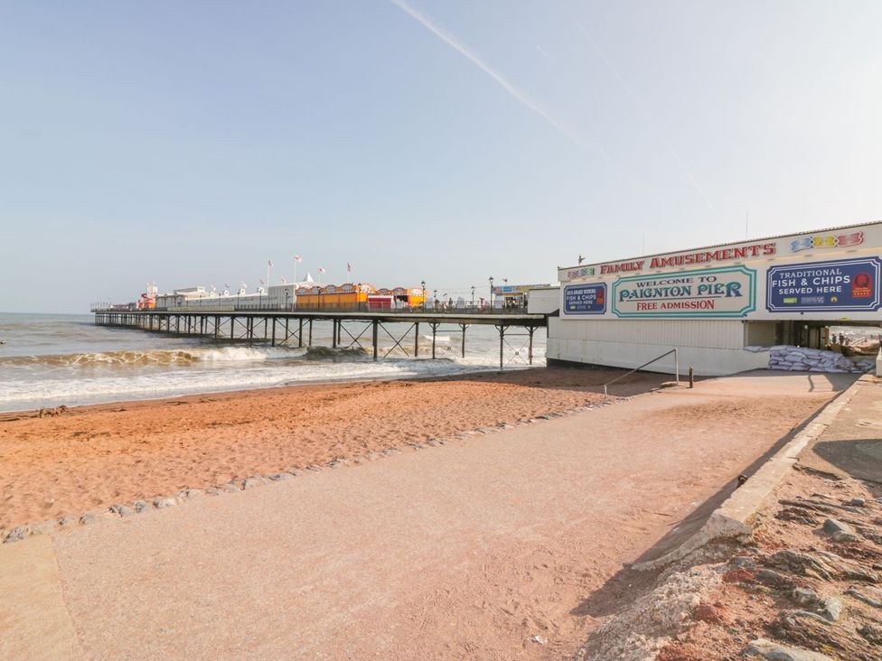 A pier with amusement signage and beach sand at Paignton Pier in Paignton