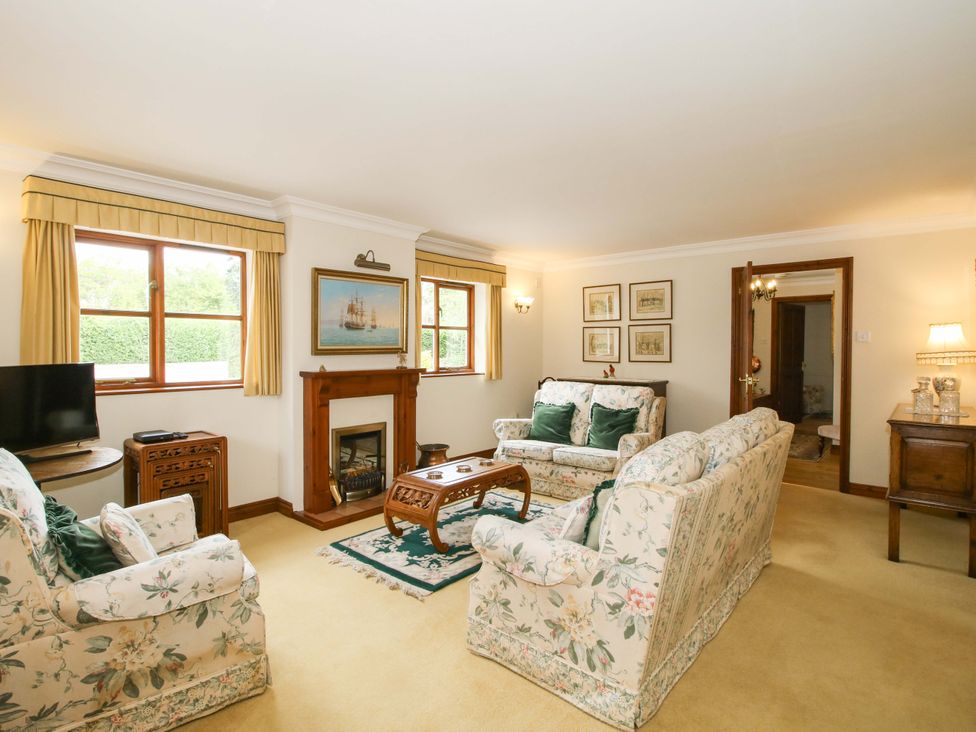 A living room with sofas and a fireplace at Willow Cottage in Lydbury North