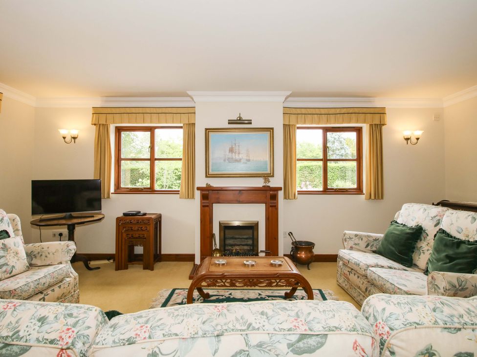 A living room with a television and a fireplace at Willow Cottage in Lydbury North