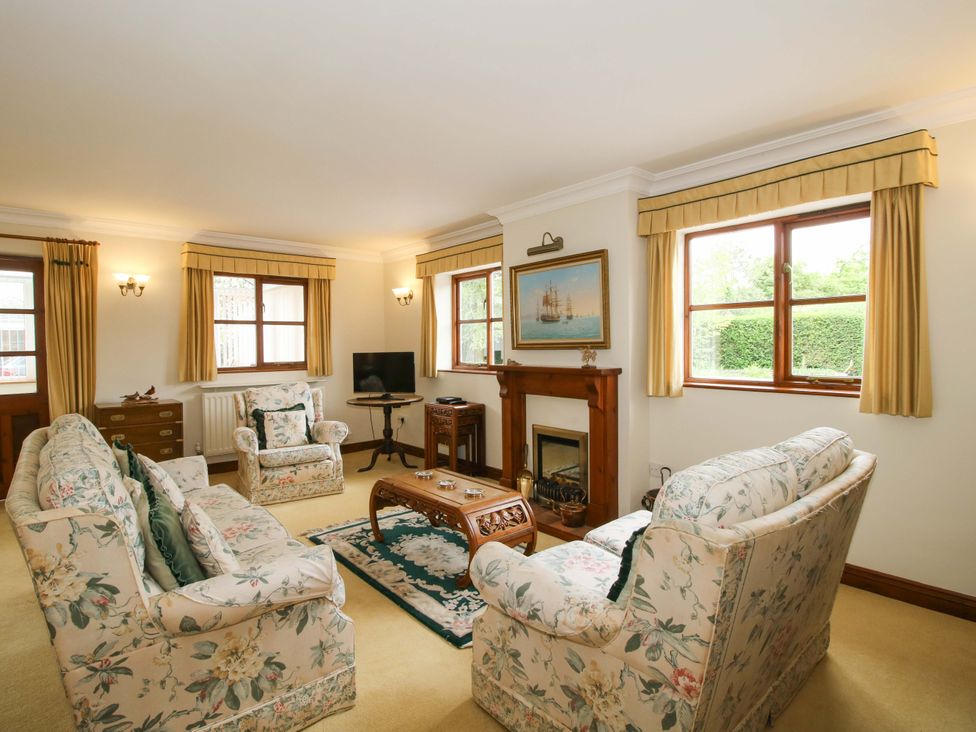 A living room with floral sofas and a coffee table at Willow Cottage in Lydbury North