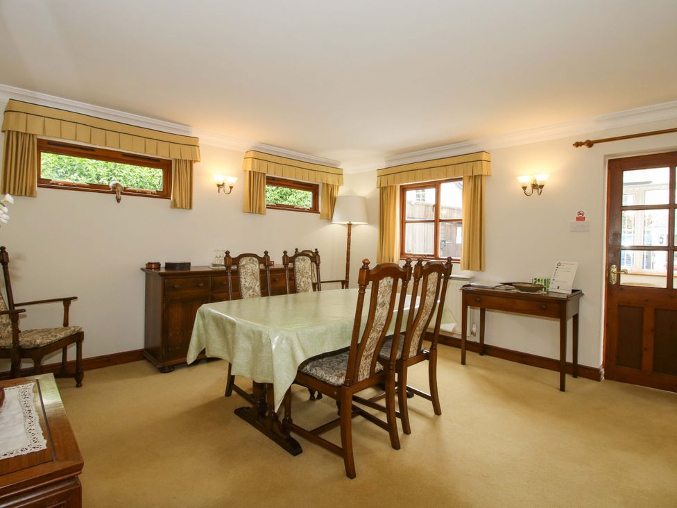 A dining room with a table and chairs at Willow Cottage in Lydbury North