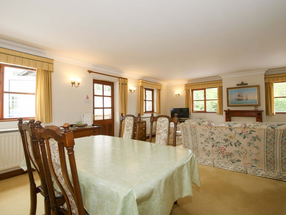 A living room with a dining table and a sofa at Willow Cottage in Lydbury North