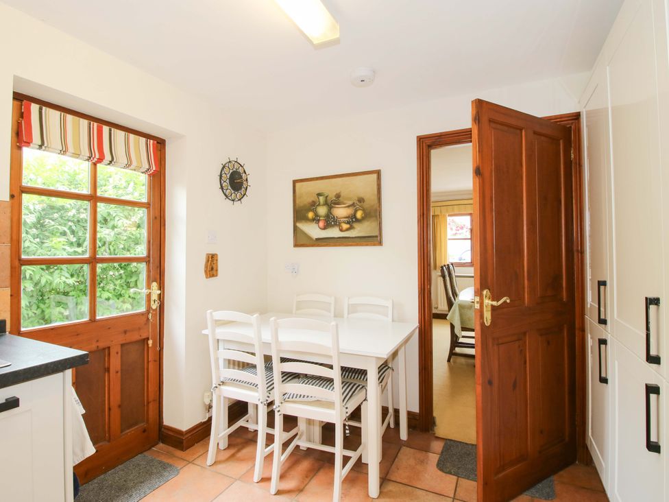 A kitchen with a table and chairs at Willow Cottage in Lydbury North