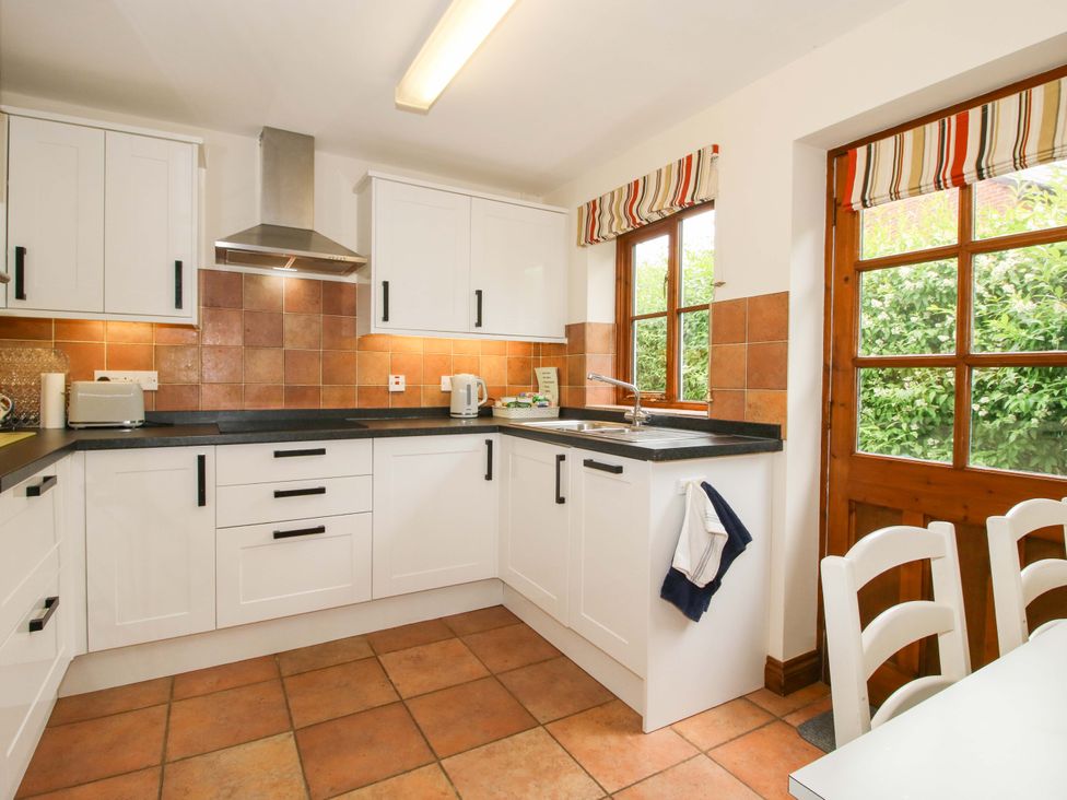 A kitchen with cabinets and countertop at Willow Cottage Lydbury North