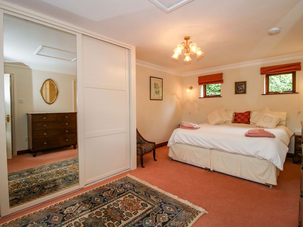 A bedroom with a bed and a dressing table at Willow Cottage in Lydbury North