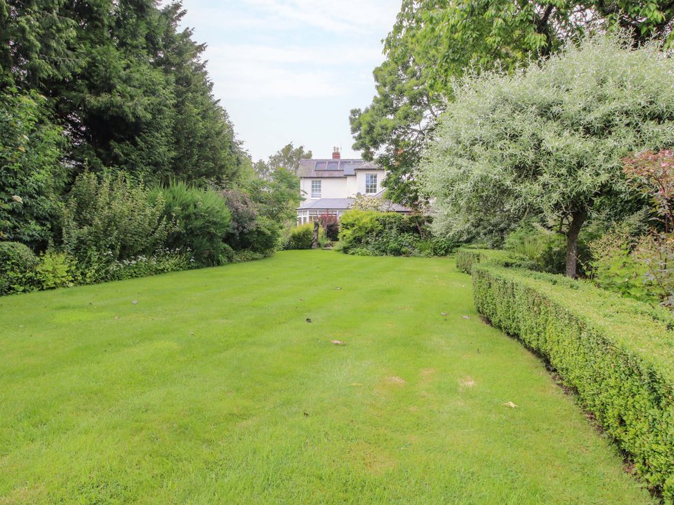 A garden with grass and trees at Willow Cottage Lydbury North