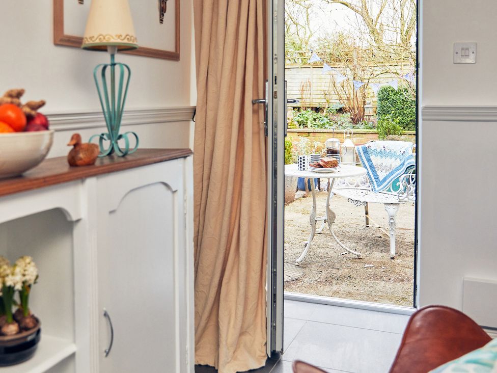 A kitchen with a door leading to an outdoor area at Apple Bough Cottage in Kinnersley