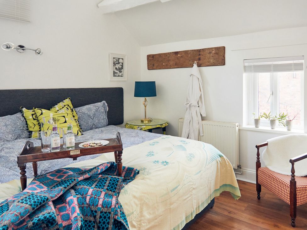 A bedroom with a bed and bedside table at Apple Bough Cottage in Kinnersley