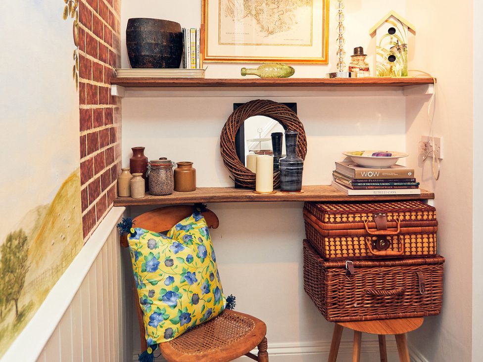 A hallway with a shelf and various decorations at Apple Bough Cottage, Kinnersley