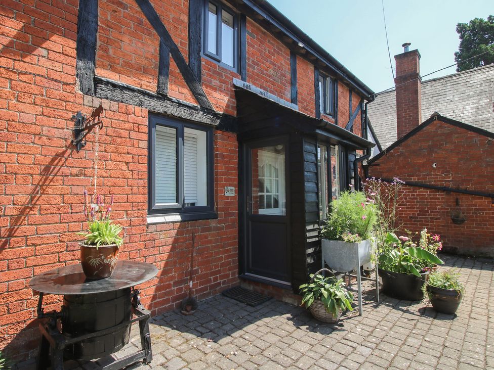 An outdoor area with plants and a front door at Apple Bough Cottage in Kinnersley near Weobley