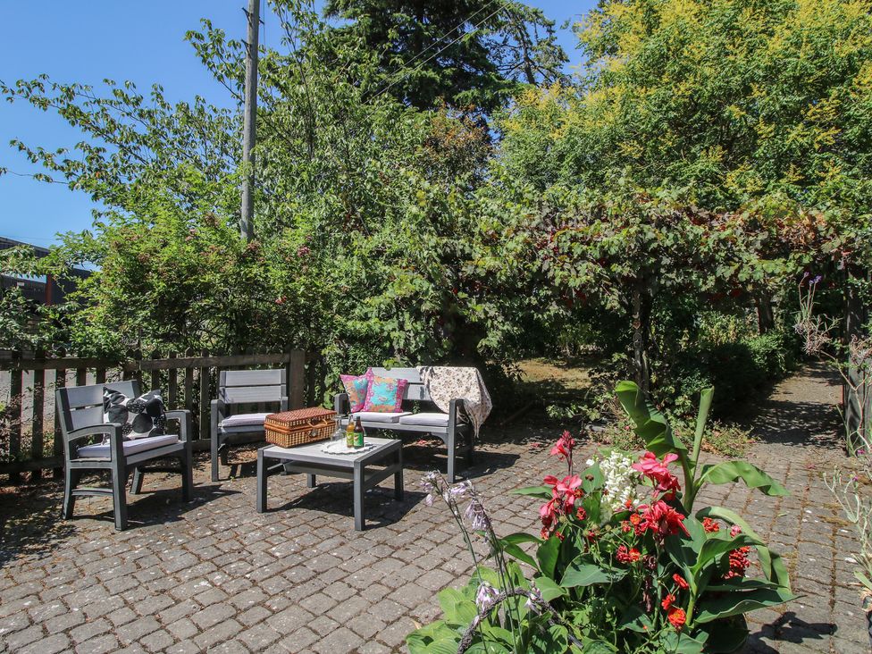 A garden with outdoor furniture and flowers at Apple Bough Cottage in Kinnersley near Weobley